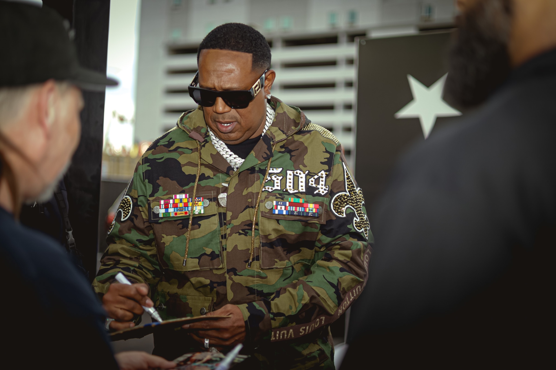 Master P signing autographs in 504 camo jacket
